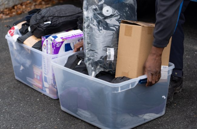 Holding a bin of donation materials