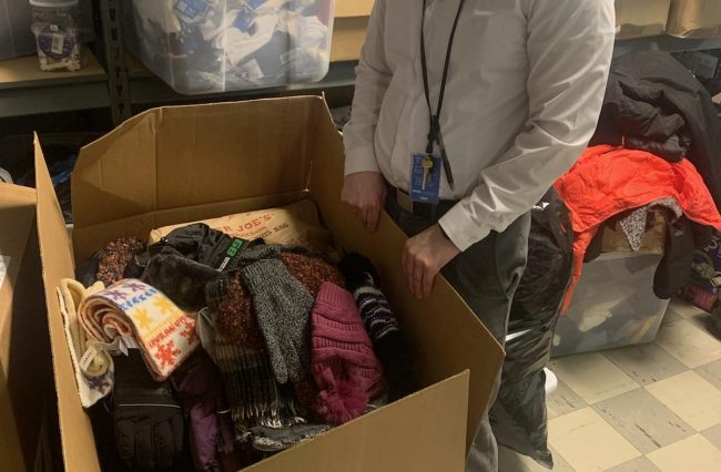 Social worker holding donations items in a box