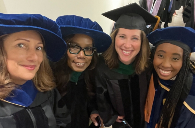 Faculty and students stand in a group photo